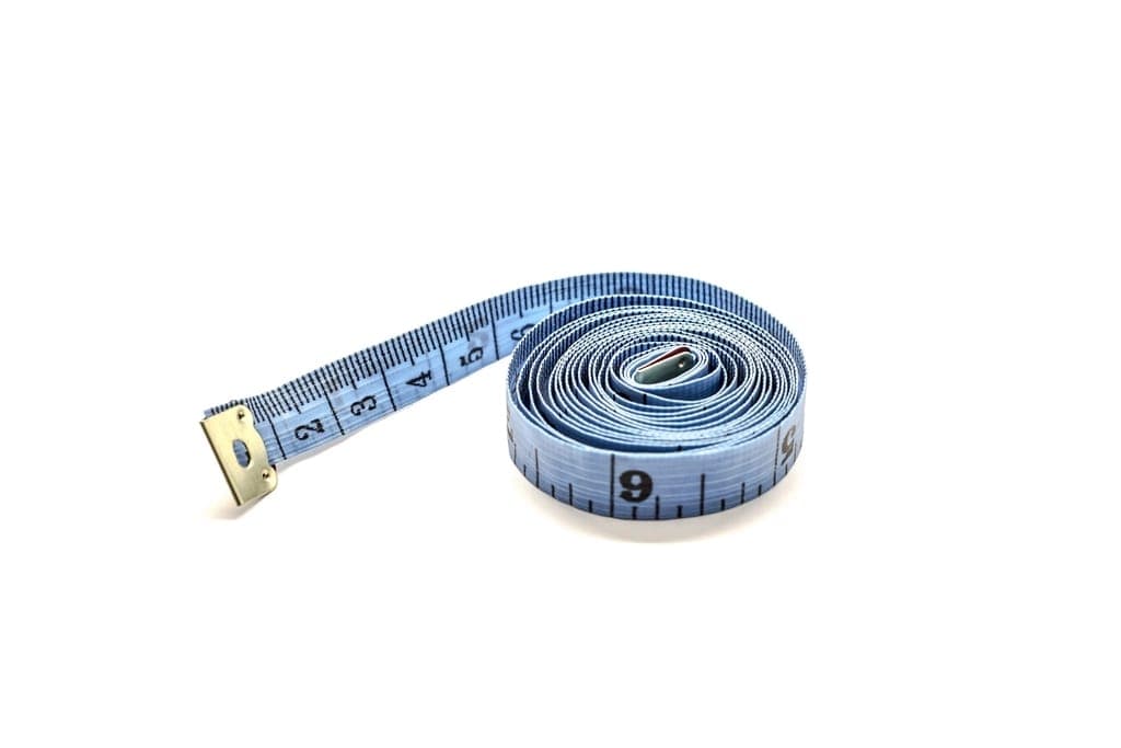 Two shoe boxes and a tape measure on a wooden floor