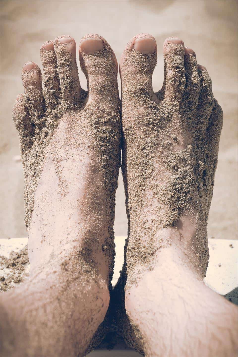 A person standing barefoot on a wooden floor seen from the side
