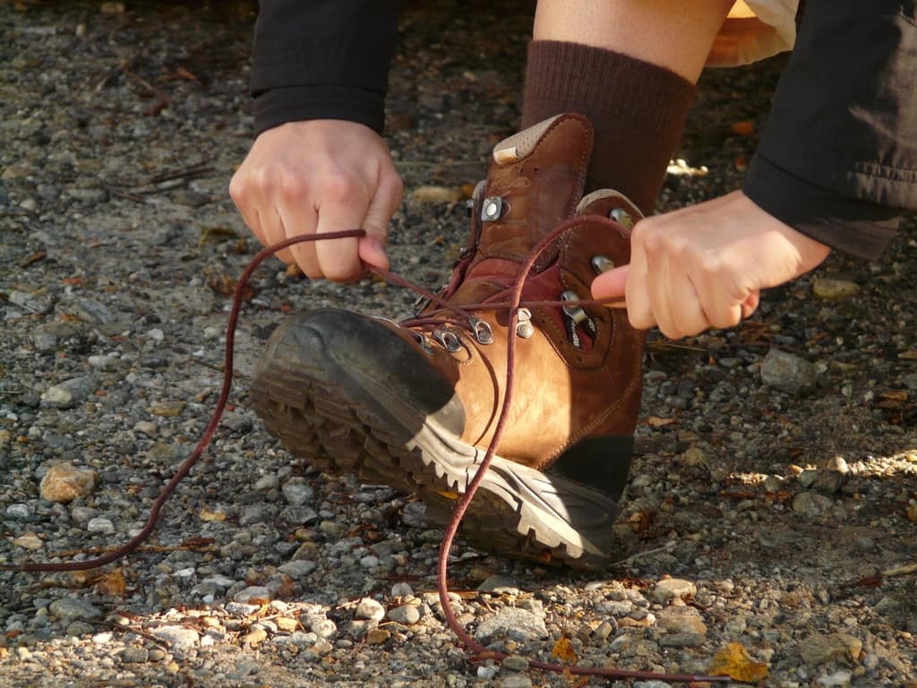 A leather minimalist hiking boot on a muddy trail