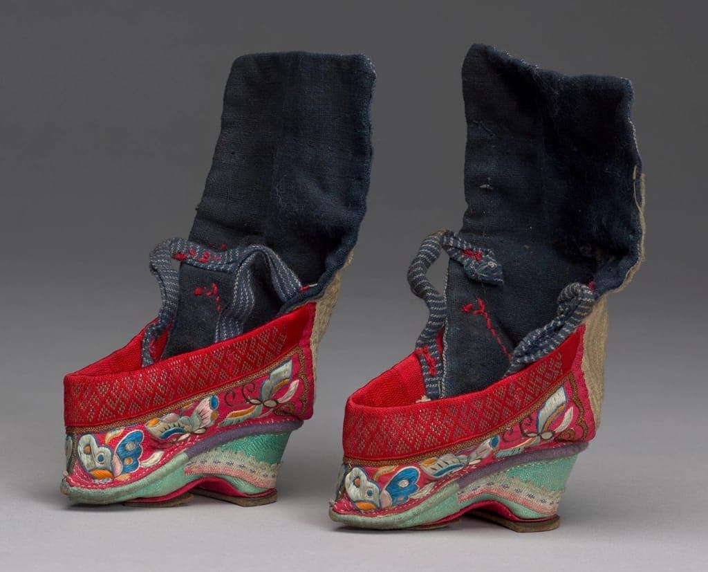 A child's flexible wide-toe-box shoe beside a bare child's foot
