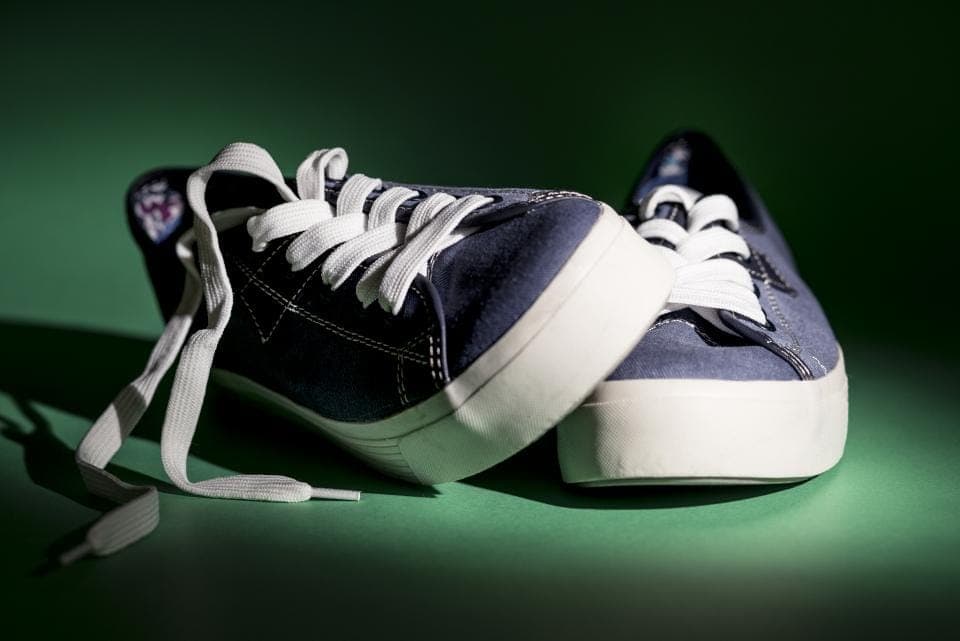 A five-toe training shoe beside a loaded barbell