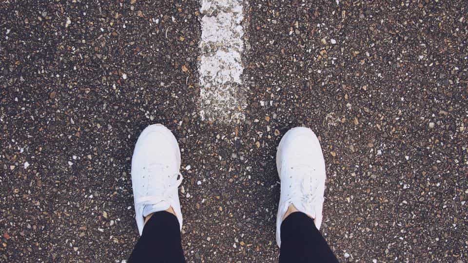 An ultra-thin knit barefoot shoe flexed to show sole thickness