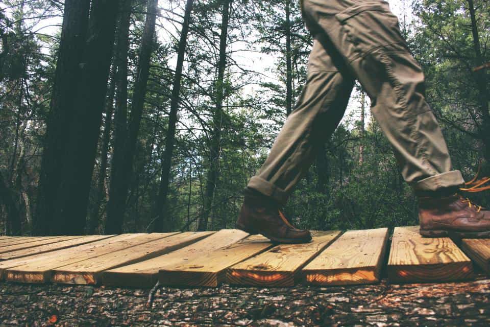 A lugged thin-soled trail shoe on wet forest ground