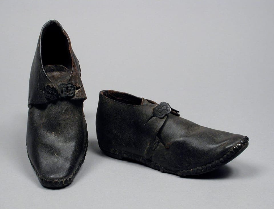 A small child's wide-toe-box pull-on shoe on grass