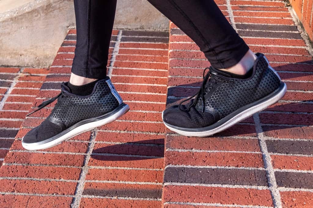 A cushioned running shoe beside a thin minimalist running shoe