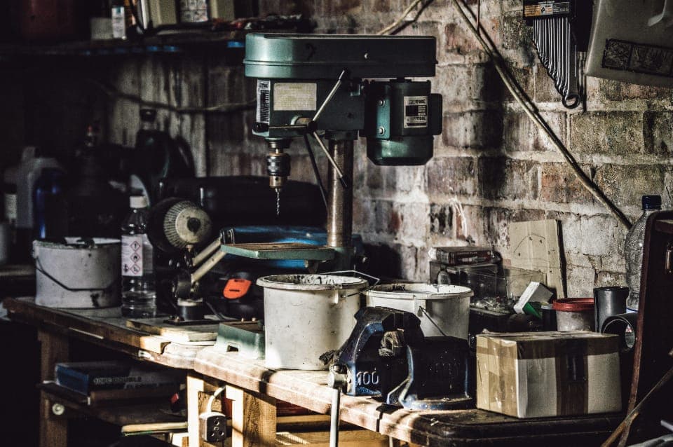A person standing at a workbench on a hard floor