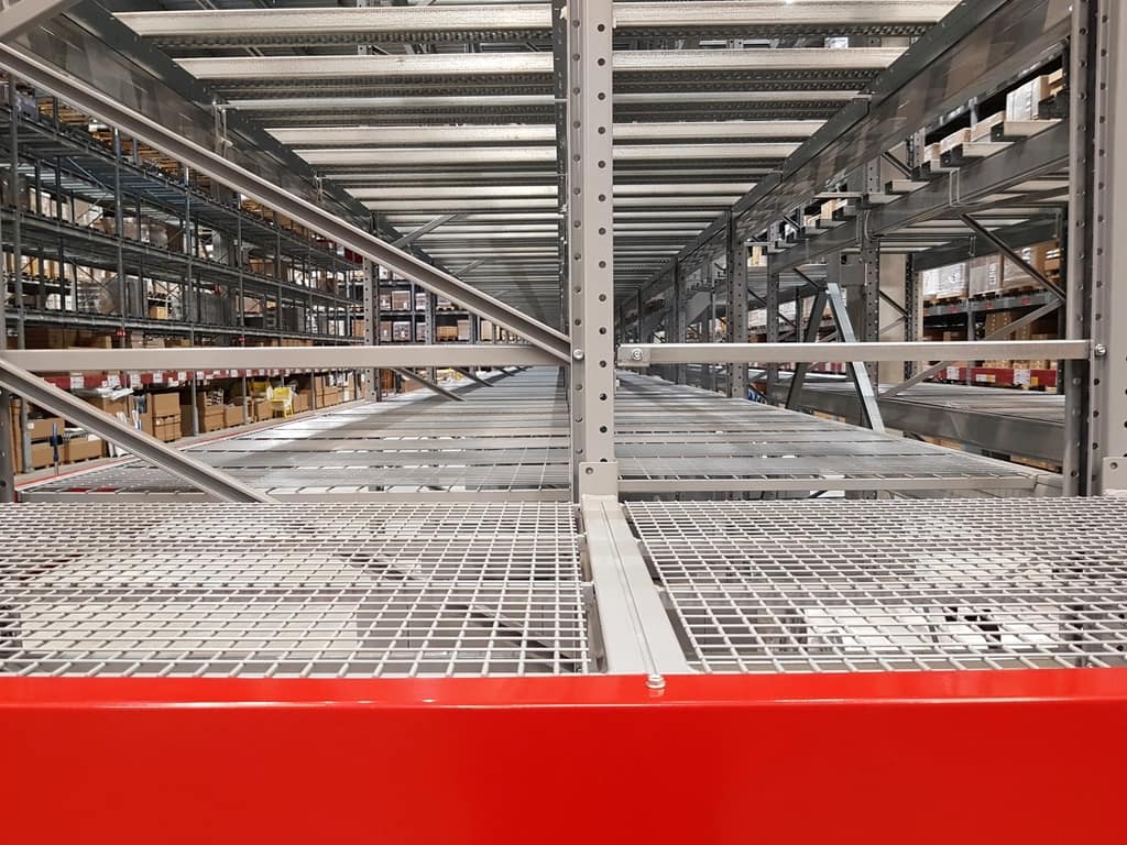 A warehouse aisle with pallet racking and a concrete floor